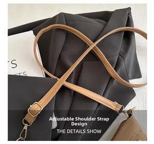 Detail of brown faux leather adjustable shoulder strap with light gold metal hardware