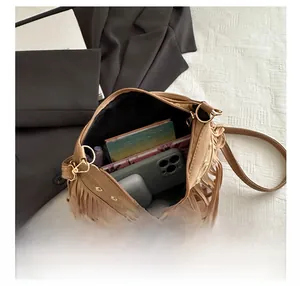Internal view of brown tassel saddle bag showing capacity for phone and accessories