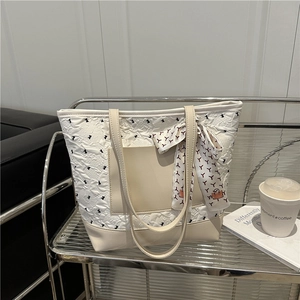 Chic cream tote bag with black bow patterns and silk scarf handle decoration