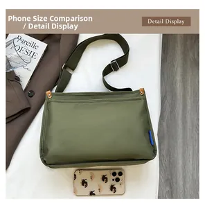 Detailansicht grüne Messenger Bag aus Nylon mit Smartphone zum Größenvergleich