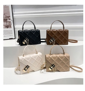Detail view of quilted chain bags in black brown beige and cream with gold hardware