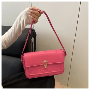Detail of hot pink lychee leather handbag featuring a gold water-drop metal clasp