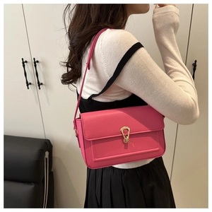 Detail of hot pink lychee textured shoulder bag with golden water drop metal buckle