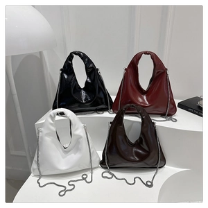 Detail of four glossy PU leather hobo bags in black, burgundy, white and brown with chains