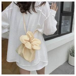 Detail of yellow checkered drawstring bag showing floral petal shape and cotton texture