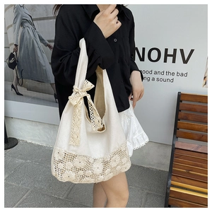 Detail view of large canvas shoulder bag with lace flower hollow design