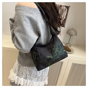 Detail of black Hobo bag with green leaf embroidery and adjustable nylon strap