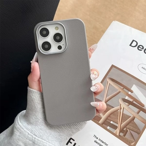 Minimalist grey faux leather iPhone case with metallic camera ring on a magazine backdrop