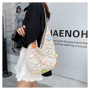 Détail du sac cabas en tricot beige avec fleurs au crochet 3D et texture en maille