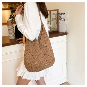 Gros plan détaillé du sac à bandoulière en tricot marron avec motif de losanges sur un modèle