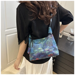 Detailed view of impressionist oil painting pattern and wide strap on canvas bucket bag