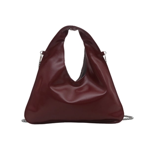 Deep red triangular patent tote bag with silver chain strap on white background