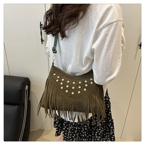 Detail of vintage brown suede bag with gold studs and long tassel fringe strap