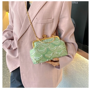 Detail of mint green lace crossbody bag with sequins and golden metal kiss-lock clasp