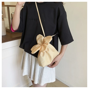 Detail of yellow checkered floral knot canvas bucket bag with slim shoulder strap