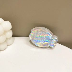 Detailed holographic fish-shaped phone grip with scales and fins on a white platform