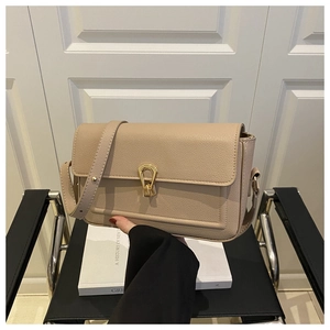 Close-up of beige pebble leather shoulder bag with a unique gold U-shaped metal buckle