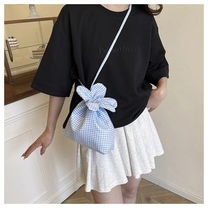 Detail view of blue checkered canvas bucket bag with drawstring closure and floral embroidery