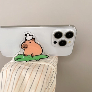 Detailed view of an acrylic phone grip featuring a cute cartoon capybara on a crocodile