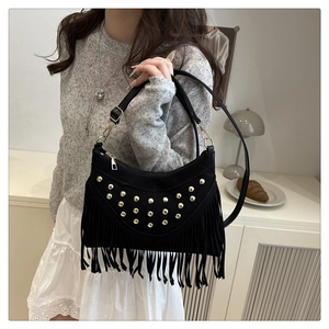 Detail of black bohemian tassel bag with gold rivets and adjustable shoulder strap