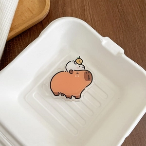 Macro shot of cute acrylic capybara phone stand with orange head decoration