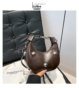 Detailaufnahme der kaffeebraunen Croissant-Tasche mit Nieten und glattem Lederfinish