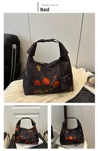 Detail of Chinese style bucket bag showing red persimmon embroidery and buckle closure