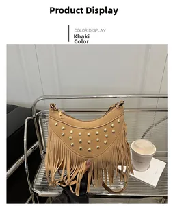 Detail of khaki saddle bag featuring gold studs and long fringe tassels in lifestyle setting