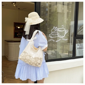 Elegant Korean style hollow flower canvas shoulder bag with lace detail in a summer cafe