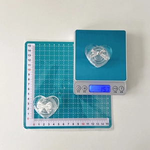 Transparent heart-shaped phone grip with white bow detail showing weight on a scale