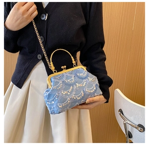 Close-up of light blue lace crossbody bag with sequins and vintage metal clasp handle
