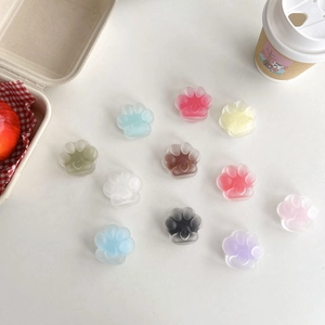 Flat lay of colorful matte translucent cat paw phone grips with heart-shaped center details