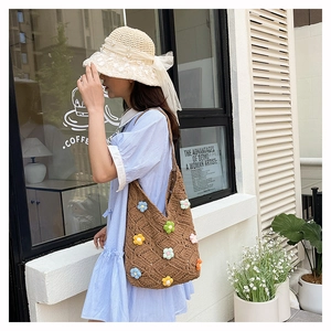 Détail d'un sac cabas en tricot marron avec fleurs au crochet 3D et maille ajourée