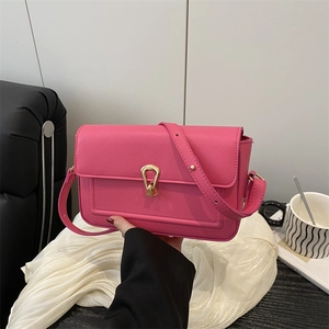 Minimalist hot pink lychee leather shoulder bag with golden U-shaped buckle and long strap