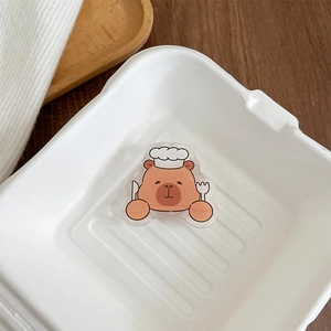 Close-up of a cute capybara chef acrylic phone socket decoration inside a lunch box