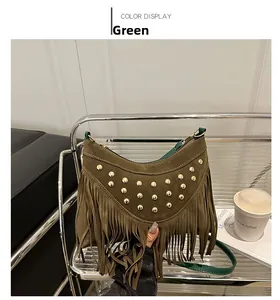 Detail of green suede crossbody bag with gold studs and bohemian fringe accents