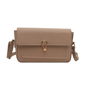 Retro khaki pebbled leather shoulder bag with gold teardrop lock on white background