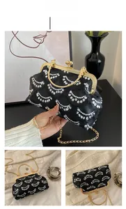 Detail of a vintage evening handbag with white sequins and gold metal clasp closure