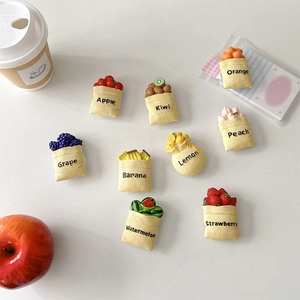 Set of 9 creative fruit resin phone sockets in cute yellow fabric pouches on white background