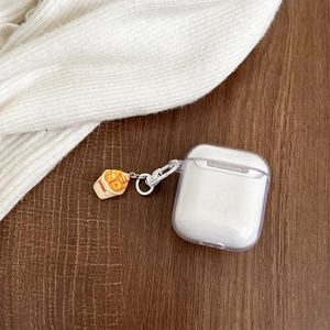 Detail of clear AirPods case with creative mini 3D croissant charm and sweet pendant