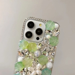 Detail of luxury rhinestones, resin roses and pearls on a clear phone case cover