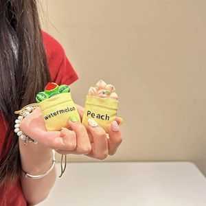 Close-up of cute fruit-themed silicone earphone case with a small yellow fabric pouch