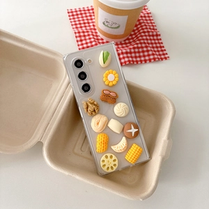 Detailed view of transparent phone case featuring 3D resin food charms in a lunch box