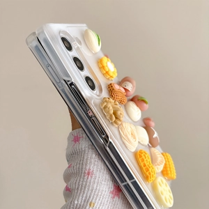 Detailed view of 3D miniature food charms on a transparent foldable Samsung case
