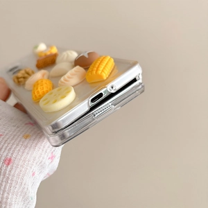 Detail of transparent phone case with 3D miniature corn, mushroom, and dumpling charms