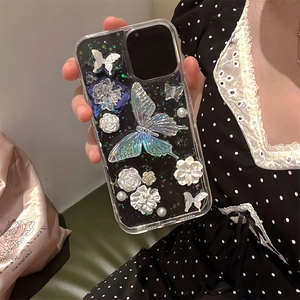 Detail view of iPhone case with 3D butterfly, pearl flowers and holographic sequins