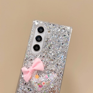 Macro view of silver glitter phone case with pink bow and heart-shaped fruit shaker charm