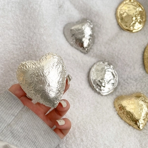 Macro detail of oval and heart shaped phone grips with unique wrinkled metal texture