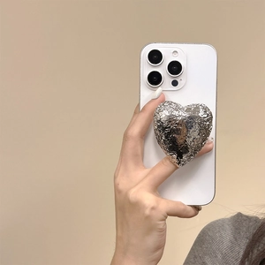 Detail of silver heart phone socket with tinfoil texture on a white smartphone