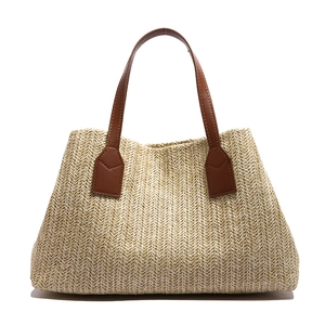 Minimalist woven straw handbag with brown handles for 2025 summer beach vacations